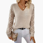 Woman wearing beige knitted V-neck jumper with open sleeve detail