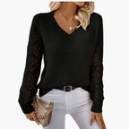 Woman wearing black knitted V-neck jumper with open sleeve detail