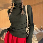 Woman wearing black ribbed turtleneck slim fit jumper