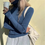 Woman wearing blue ribbed turtleneck slim fit jumper