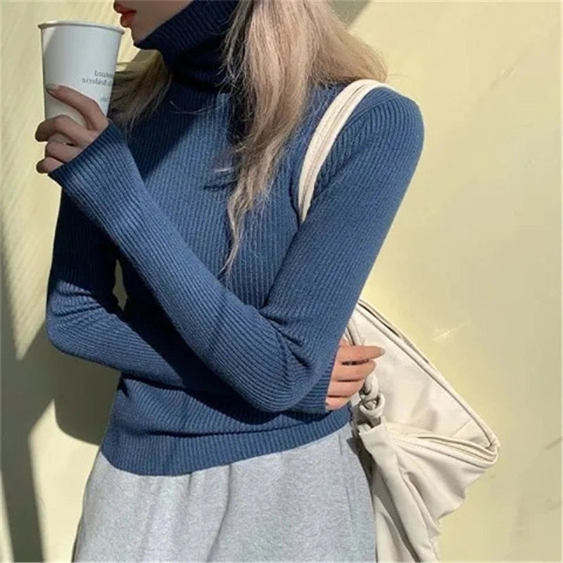 Woman wearing blue ribbed turtleneck slim fit jumper