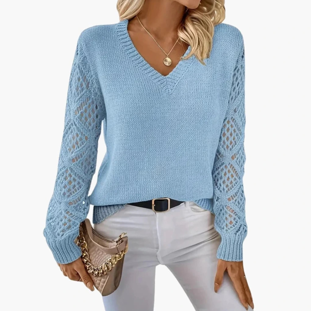 Woman wearing light blue knitted V-neck jumper with open sleeve detail