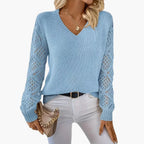 Woman wearing light blue knitted V-neck jumper with open sleeve detail