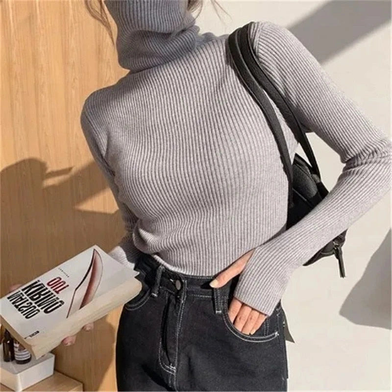 Woman wearing light grey ribbed turtleneck slim fit jumper