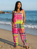 Woman wearing a jumpsuit with a pink, magenta and black abstract geometric print on the beach