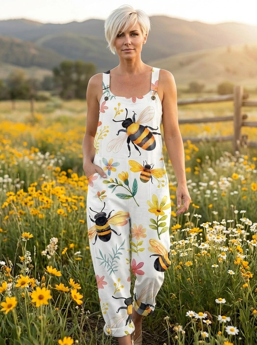 Woman in a white bee and blossom print jumpsuit walking through a flower field