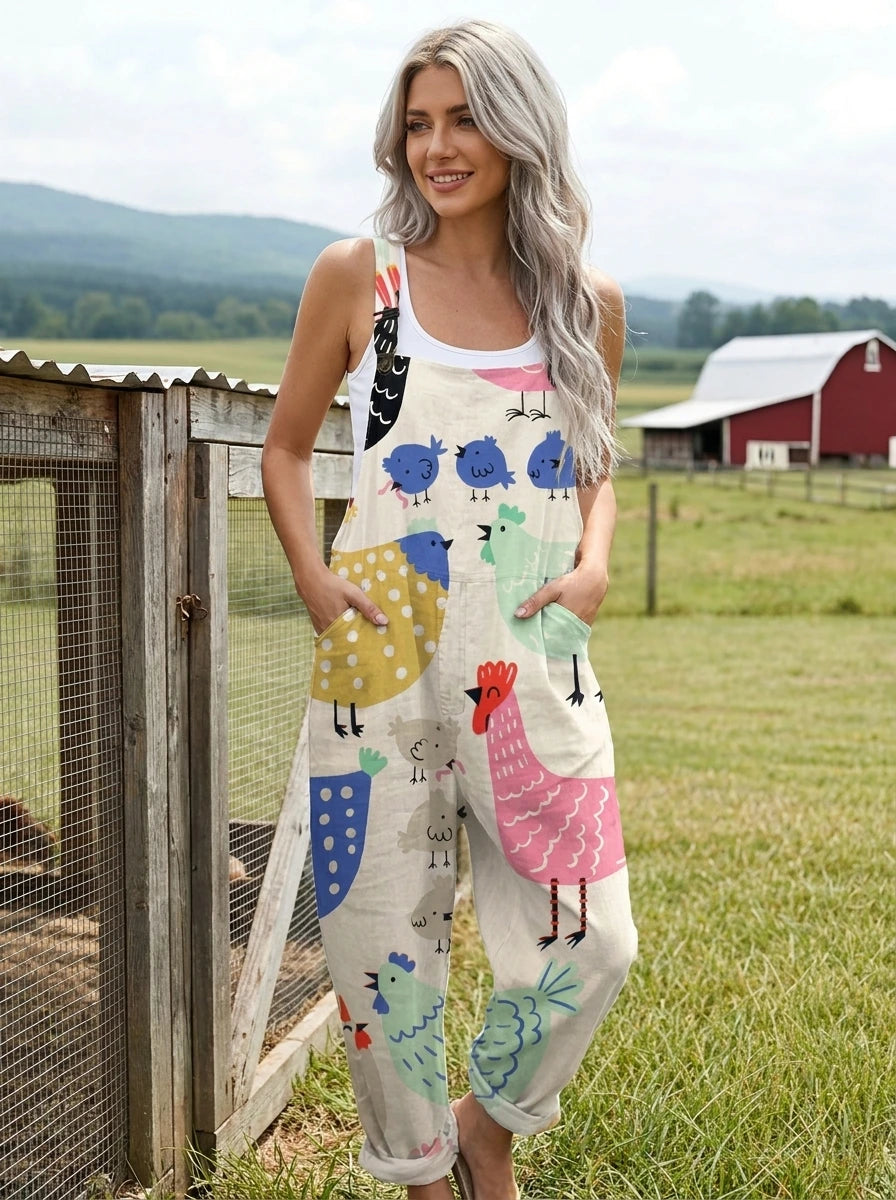 Woman wearing a cream colorful bird print sleeveless wide-leg overall jumpsuit standing in a farm field