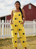 Woman wearing a yellow jumpsuit with a black bumblebee print on a farm