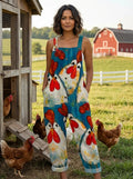 Woman wearing a teal chicken print sleeveless button-front overall jumpsuit standing in a farm setting