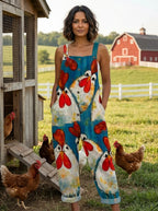 Woman wearing a teal chicken print sleeveless button-front overall jumpsuit standing in a farm setting