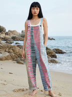 Woman wearing a coastal print sleeveless jumpsuit on a beach