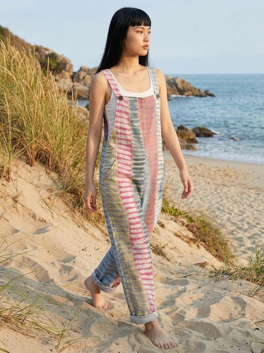 Woman walking near beach dunes wearing a coastal print sleeveless jumpsuit