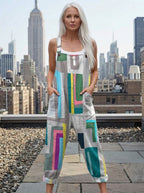 Woman wearing a grey multicolor geometric color-block wide-leg overall jumpsuit standing on a city rooftop