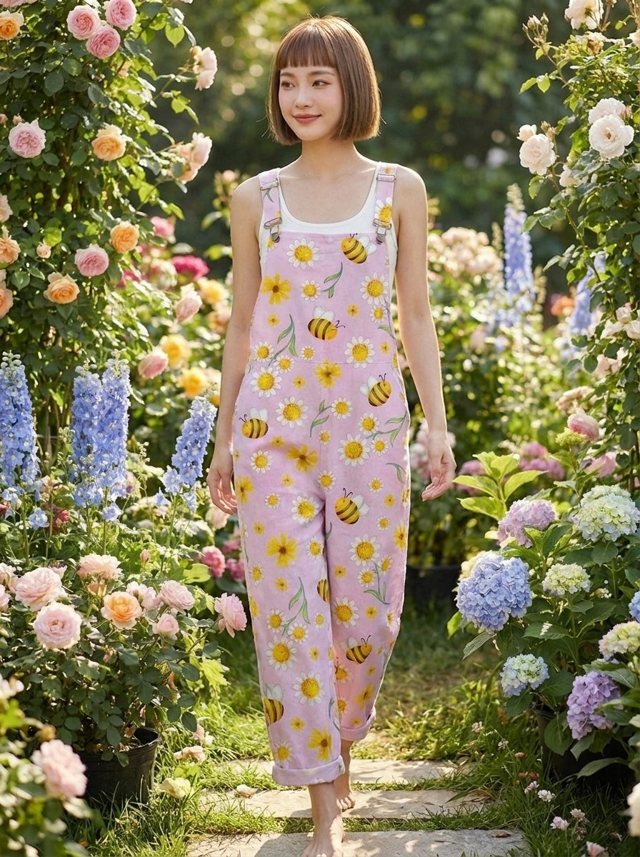Woman in a lavender daisy and bee print jumpsuit walking along a garden path