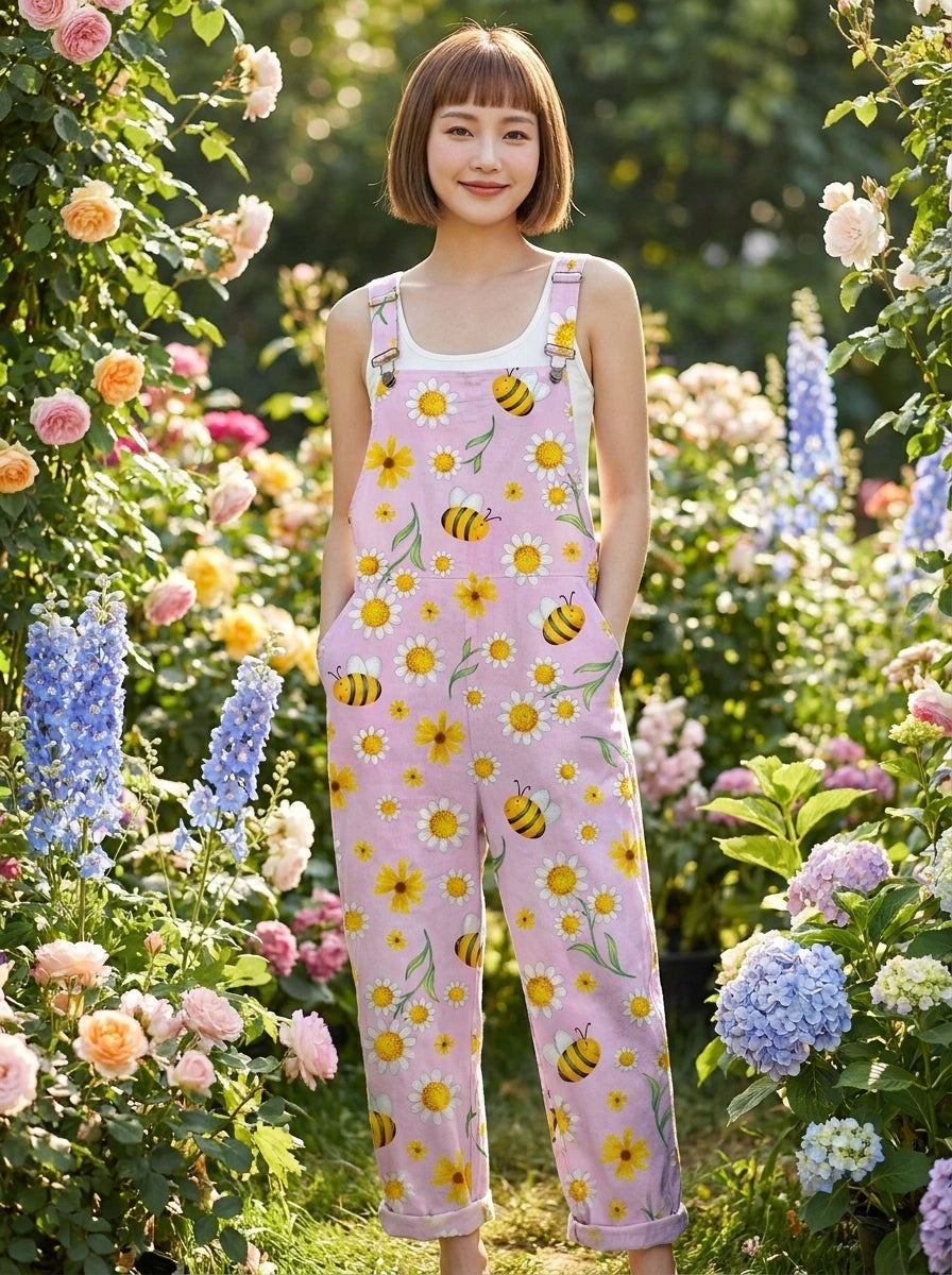Woman wearing a pink-lavender jumpsuit with a yellow daisy and bee print in a garden