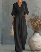 Woman wearing a black elegant wide-leg jumpsuit - studio photo