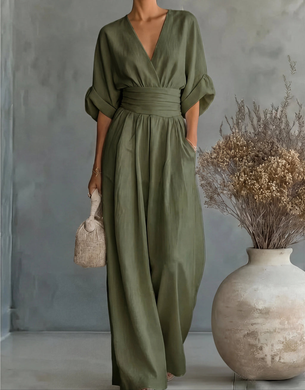 Woman wearing a green elegant wide-leg jumpsuit - studio photo