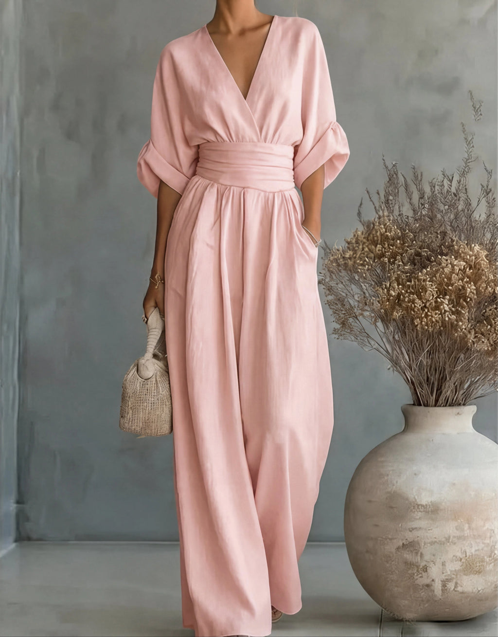 Woman wearing a light pink elegant wide-leg jumpsuit - studio photo