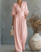 Woman wearing a light pink elegant wide-leg jumpsuit - studio photo