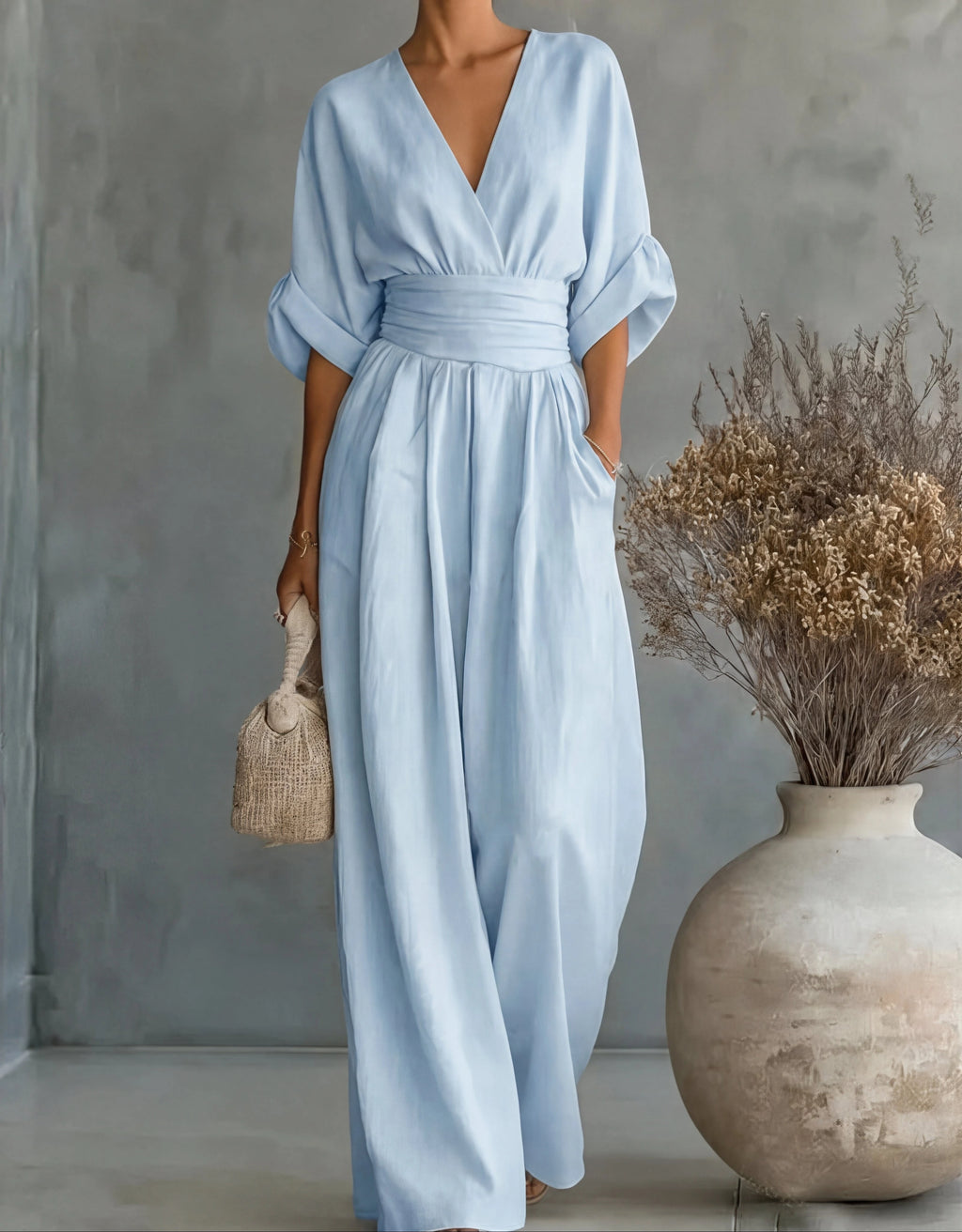 Woman wearing a sky blue elegant wide-leg jumpsuit - studio photo