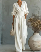 Woman wearing a white elegant wide-leg jumpsuit - studio photo