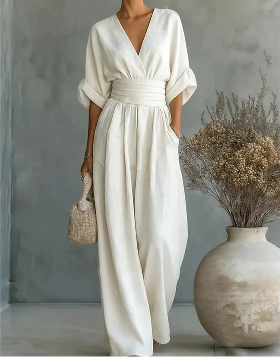 Woman wearing a white elegant wide-leg jumpsuit - studio photo