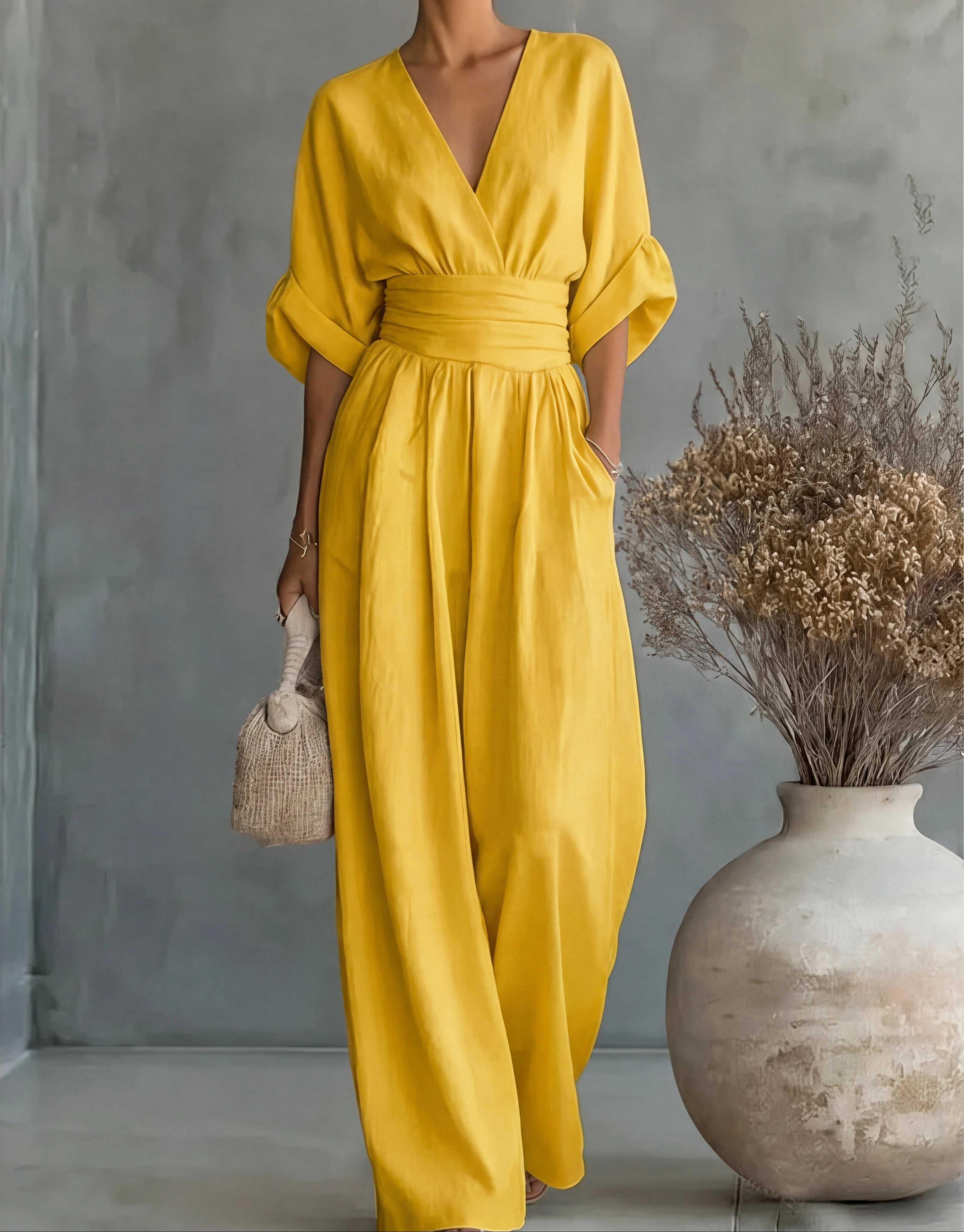 Woman wearing a yellow elegant wide-leg jumpsuit - studio photo