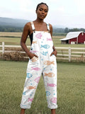 Woman wearing a white jumpsuit with a colorful fish print on a farm