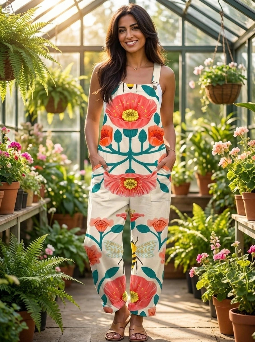 Woman in a cream floral bloom print jumpsuit standing inside a sunlit greenhouse