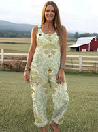 Woman wearing a sage-green jumpsuit with a gold floral damask print on a farm
