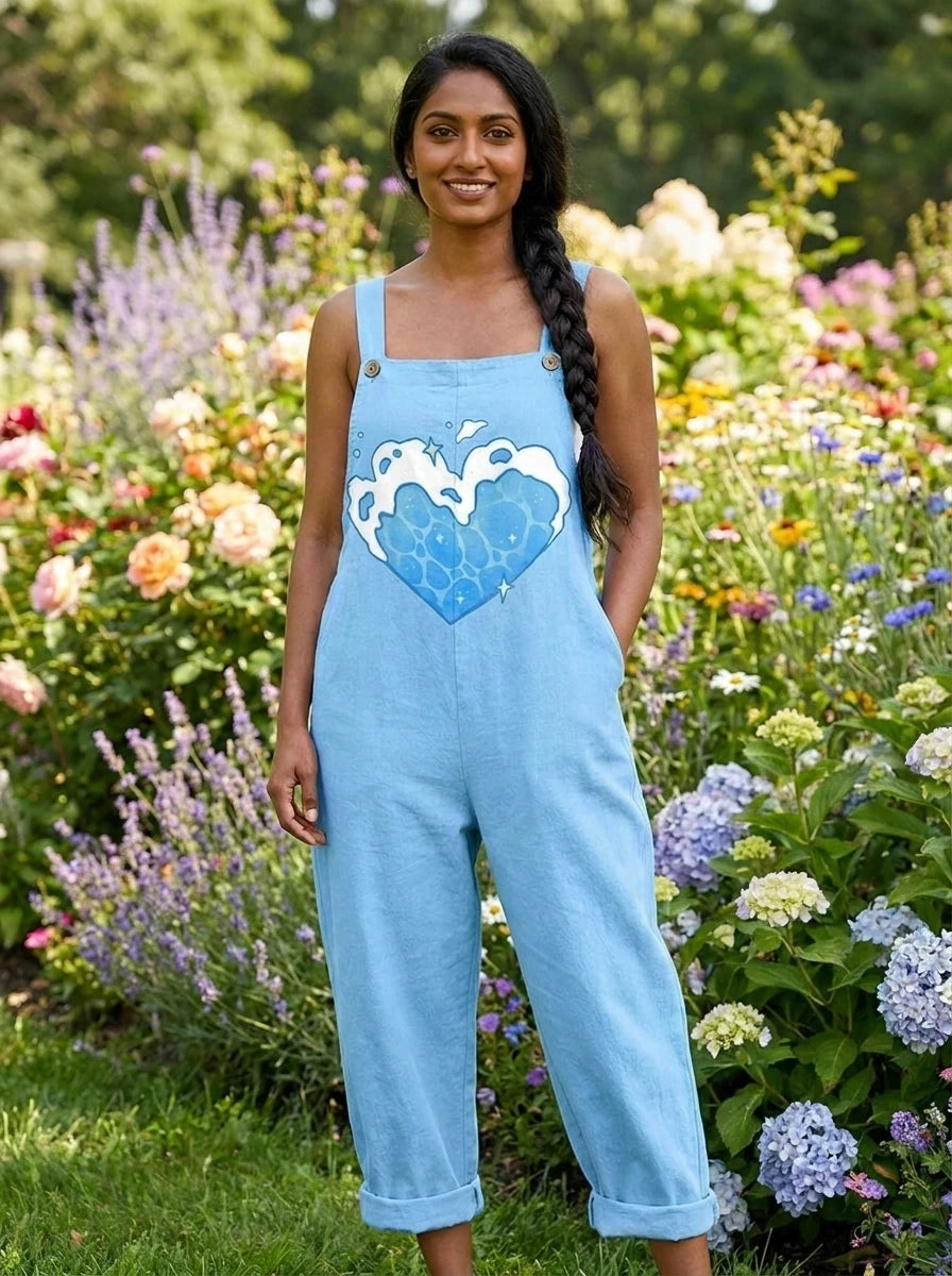 Woman wearing a light-blue heart print sleeveless overall jumpsuit standing in a flower garden