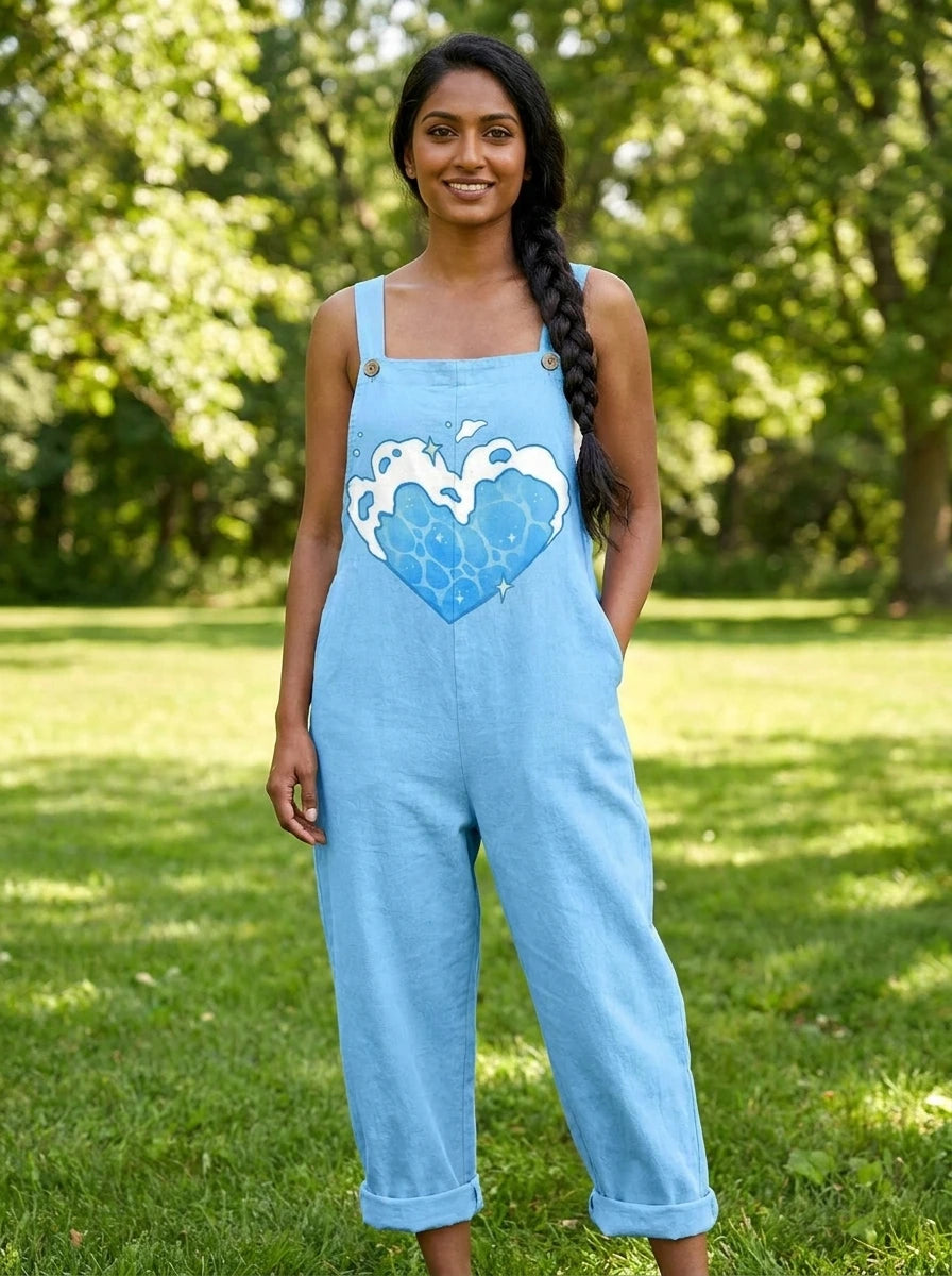 Woman wearing a light-blue heart print sleeveless overall jumpsuit standing in a green park