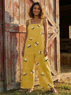 Woman standing near a barn door wearing a honeybee floral print jumpsuit