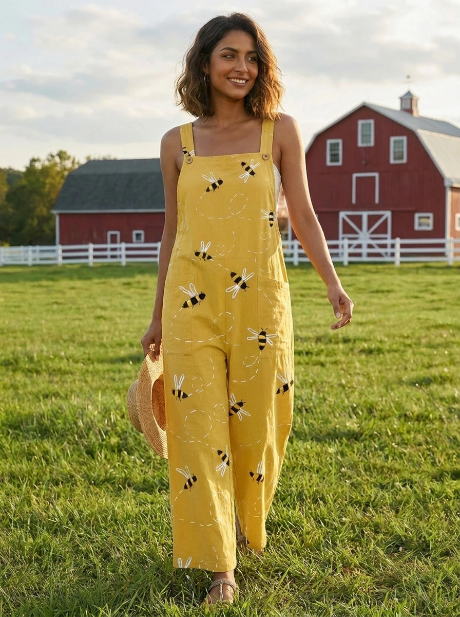 Woman walking in a farm field wearing a honeybee floral print jumpsuit