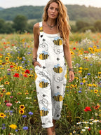 Woman wearing a white honeybee print sleeveless button-down overall jumpsuit walking through a flower field
