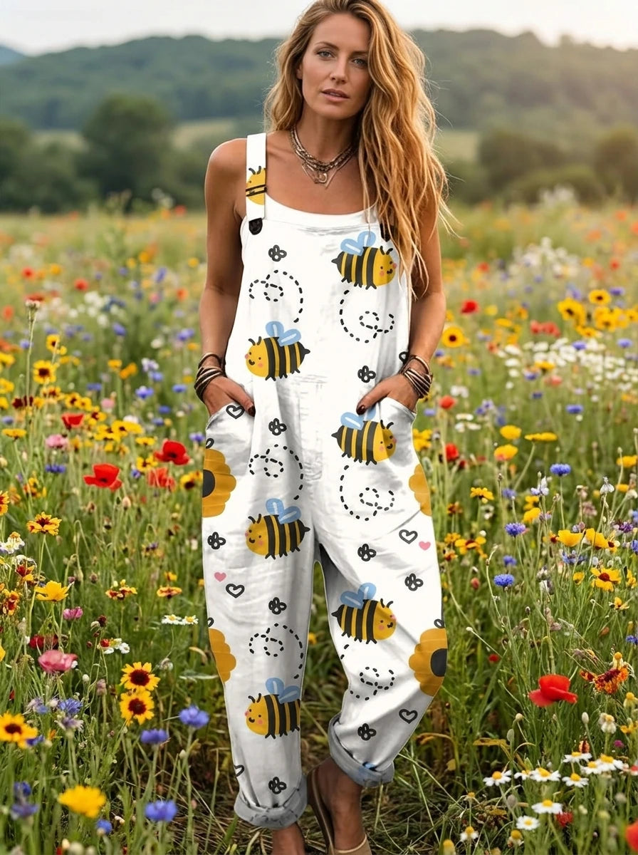 Woman wearing a white honeybee print sleeveless button-down overall jumpsuit standing in a flower field