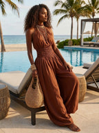 Woman wearing a brown smocked-waist wide-leg palazzo jumpsuit at a beach resort pool