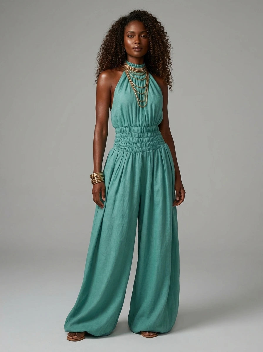 Woman wearing a green smocked-waist wide-leg palazzo jumpsuit in a studio setting