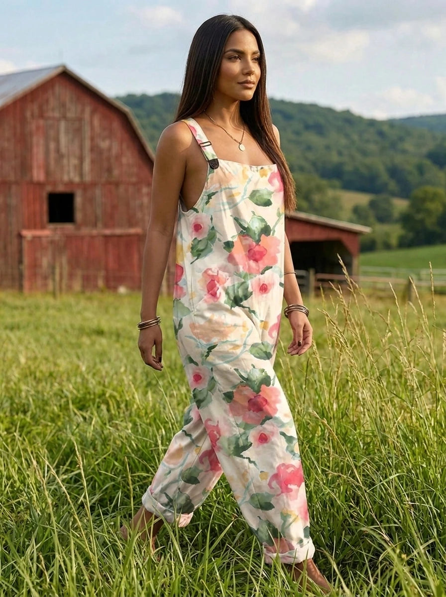 Woman walking through tall grass wearing a petal floral print jumpsuit