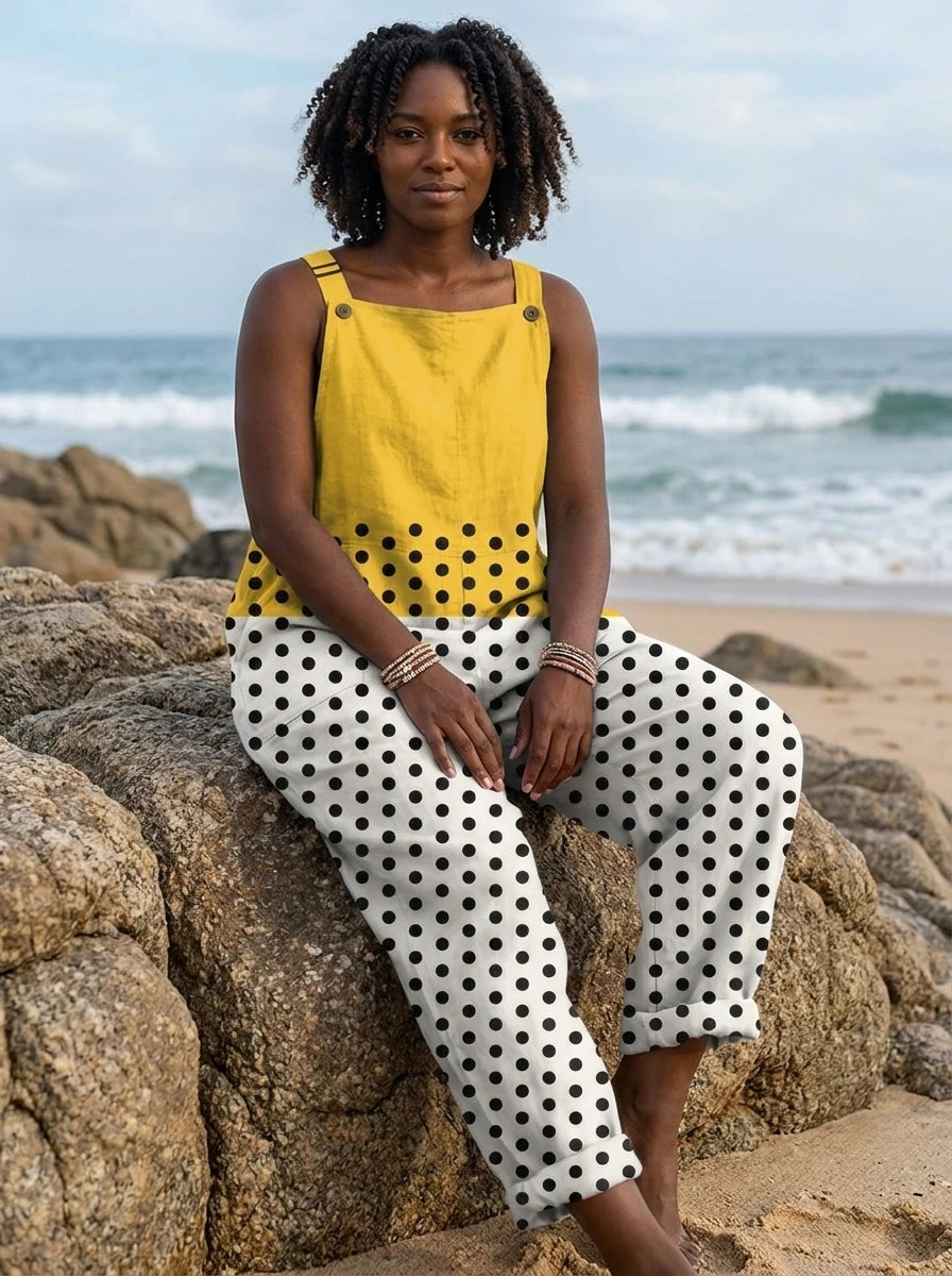 Woman wearing a yellow polka dot color-block sleeveless overall jumpsuit sitting on beach rocks