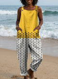 Woman wearing a yellow polka dot color-block sleeveless overall jumpsuit standing on a sandy beach