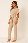 Woman wearing a beige ponte knit batwing jumpsuit - studio photo
