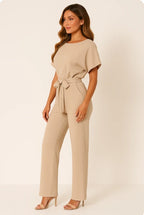 Woman wearing a beige ponte knit batwing jumpsuit - studio photo