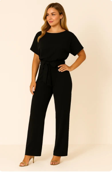 Woman wearing a black ponte knit batwing jumpsuit - studio photo