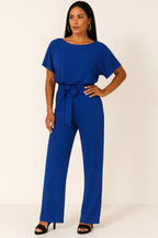 Woman wearing a blue ponte knit batwing jumpsuit - studio photo