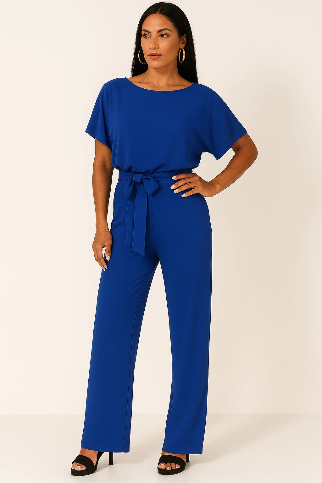Woman wearing a blue ponte knit batwing jumpsuit - studio photo
