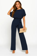 Woman wearing a dark blue ponte knit batwing jumpsuit - studio photo