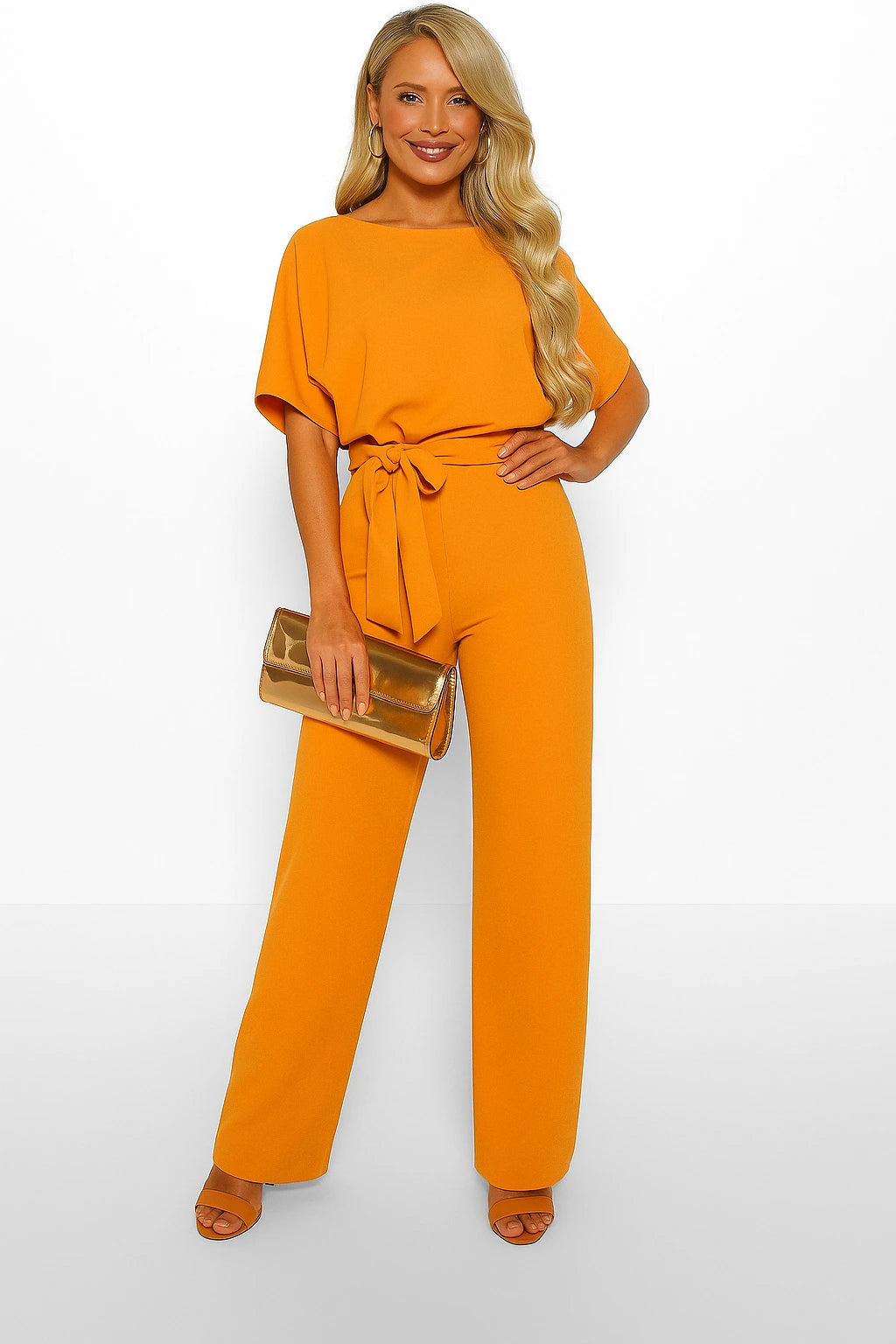 Woman wearing a mustard ponte knit batwing jumpsuit - studio photo