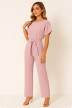 Woman wearing a pink ponte knit batwing jumpsuit - studio photo