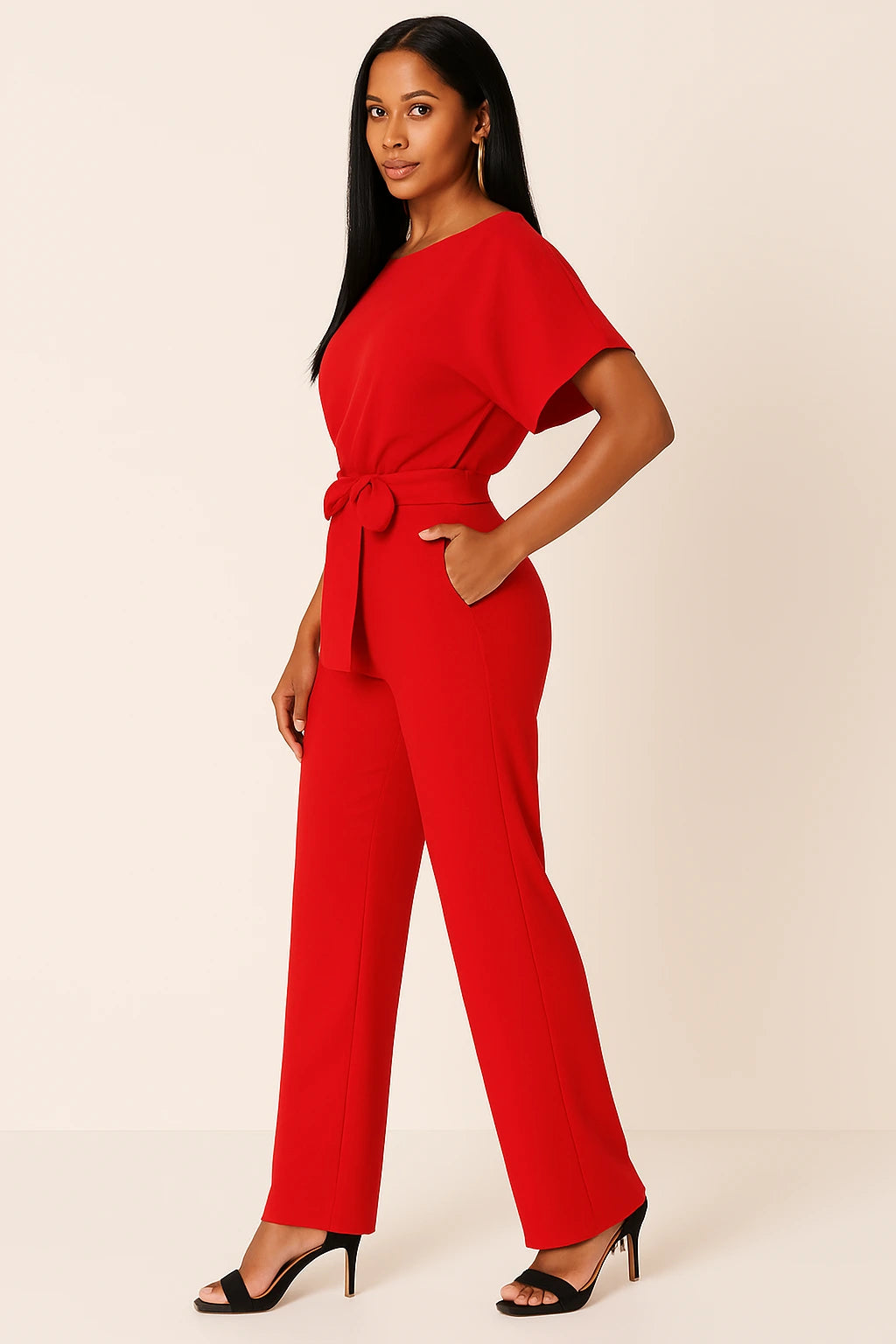 Woman wearing a red ponte knit batwing jumpsuit - studio photo